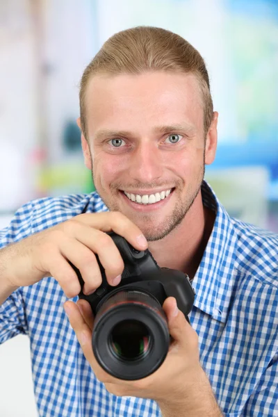 Fotógrafo bonito com câmera, em fundo brilhante — Fotografia de Stock