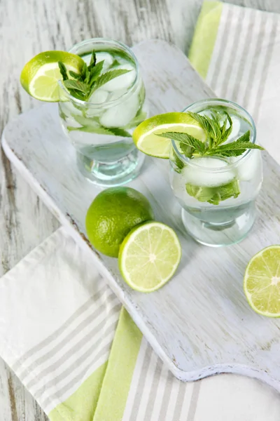 Verres de cocktail avec glace à bord sur serviette sur table en bois — Photo