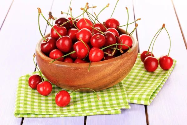 Bayas de cereza en tazón sobre mesa de madera de cerca — Foto de Stock