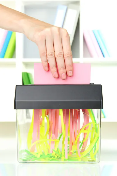 Ręczne wprowadzanie papieru do niszczarki maszyny, na tle wnętrza biura — Zdjęcie stockowe