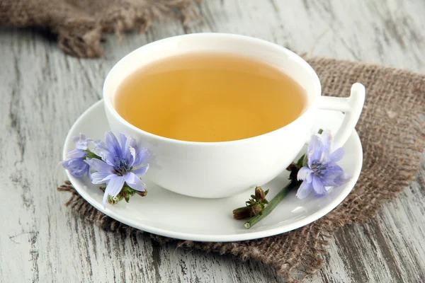 Cup of tea with chicory, on wooden background — Stock Photo, Image