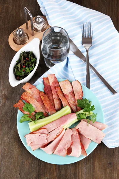 Bacon sur l'assiette sur la serviette à bord sur la table de fenêtre — Photo