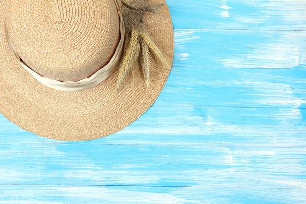 Mooie zomerse hoed met spikelets op blauwe houten achtergrond — Stockfoto