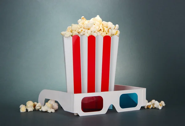 Popcorn a 3d brýle na šedém pozadí — Stock fotografie