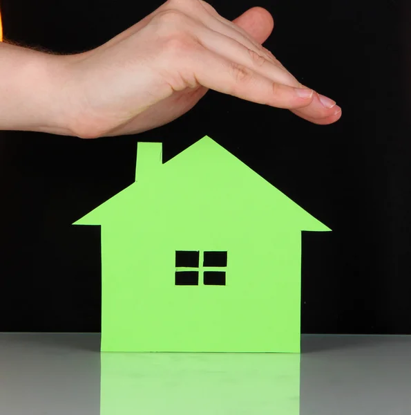 Paper house in hand on green background — Stok fotoğraf