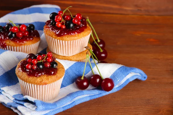 Smakelijke muffins met bessen op houten tafel — Stockfoto