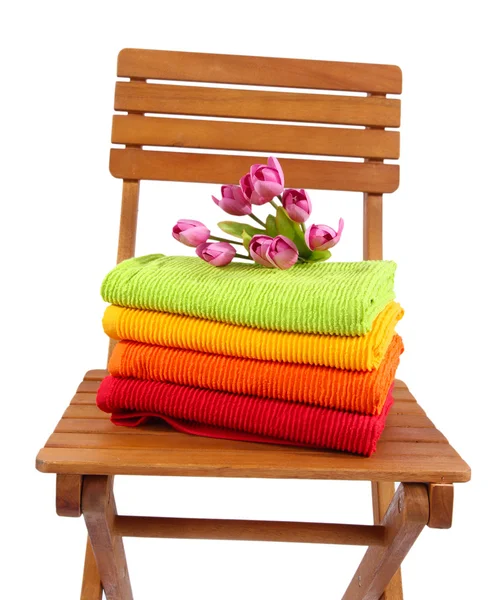 Handdoeken en bloemen op houten stoel geïsoleerd op wit — Stockfoto