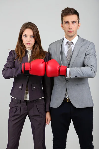 Jovens empresas em luvas de boxe em fundo cinza — Fotografia de Stock