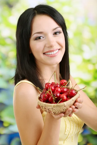 Ragazza con ciliegie fresche su sfondo naturale Fotografia Stock