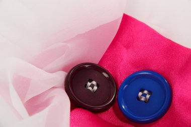 pembe ve beyaz kumaş üzerine iki düğme