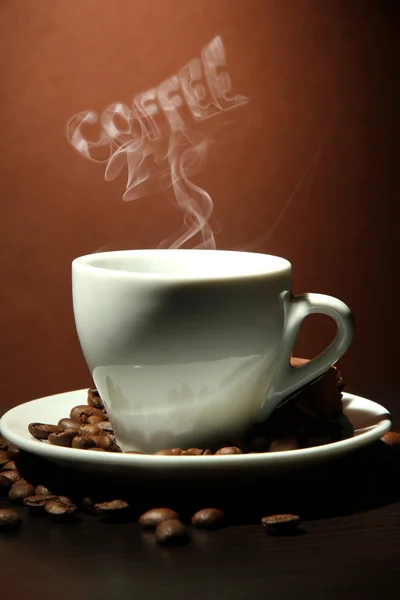 Kopp kaffe med rök i form av ord på brun bakgrund — Stockfoto