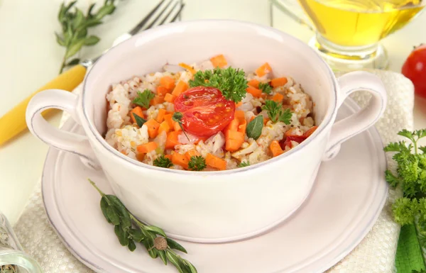 Delicious rice with vegetables and herbs in pot on wooden table close-up — Stock Photo, Image