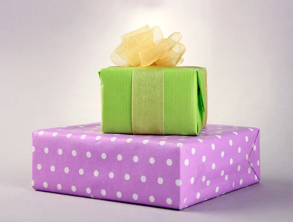 Bright gifts with bows on grey background — Stock Photo, Image