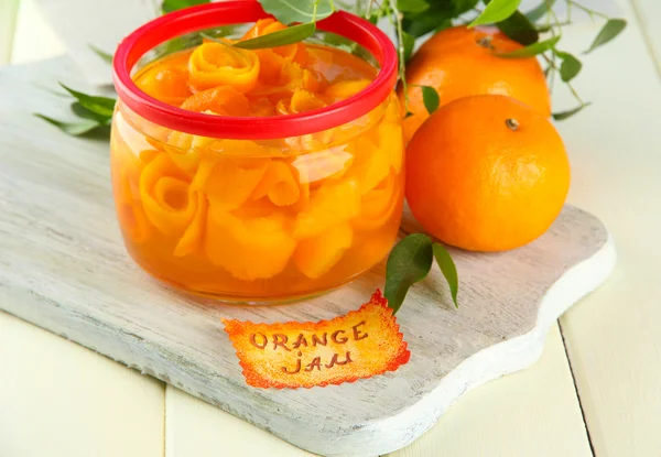 Sinaasappeljam met schil en mandarijnen, op witte houten tafel — Stockfoto