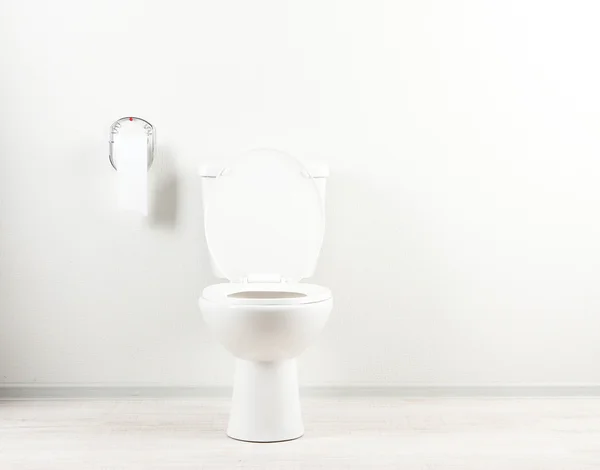 White toilet bowl and toilet paper in a bathroom — Stock Photo, Image