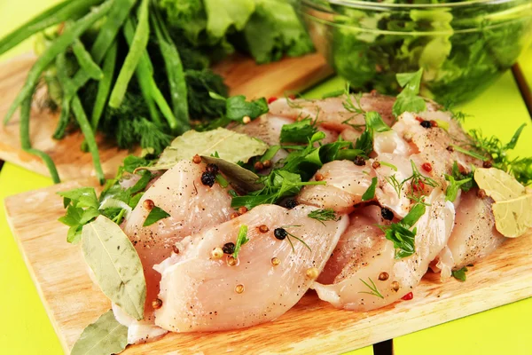 Carne di pollo in piatto di vetro, erbe e spezie sul tavolo di legno — Foto Stock