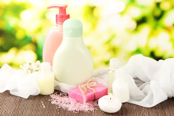 Cosmetics bottles and natural handmade soap on green background — Stock Photo, Image