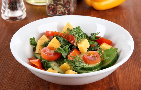 Light salad in plate on wooden table — Stock Photo, Image