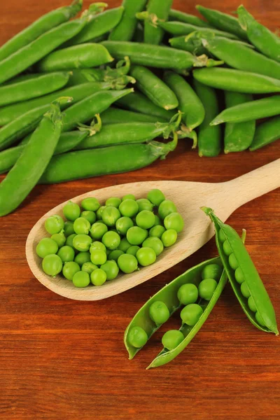 Guisantes verdes dulces sobre fondo de madera — Foto de Stock