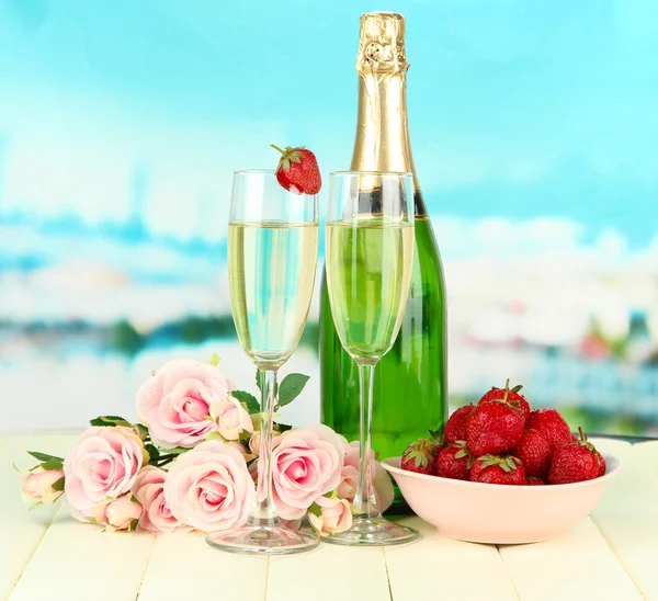 Романтический натюрморт с шампанским, клубничными и розовыми розами, на ярком фоне — стоковое фото