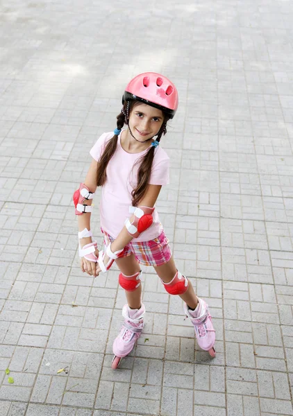 Klein meisje in rolschaatsen bij park — Stockfoto