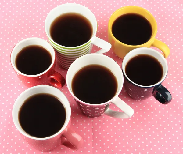 Molte tazze di caffè su tovagliolo rosa — Foto Stock