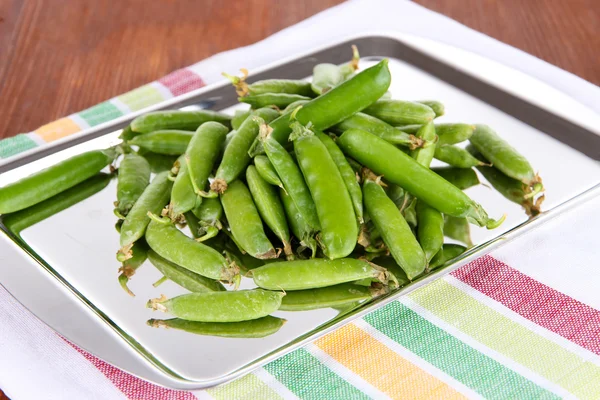 Green peas on napkin on table — Stock Photo, Image