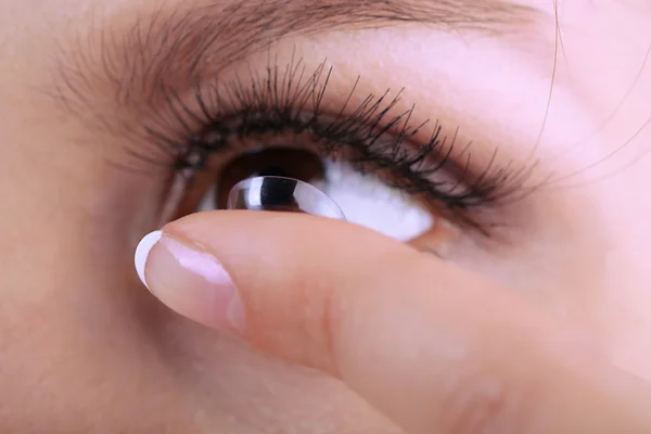 Mujer joven poniendo lentes de contacto en su ojo de cerca — Foto de Stock