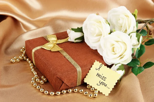 Paquete romántico sobre fondo de tela dorada —  Fotos de Stock