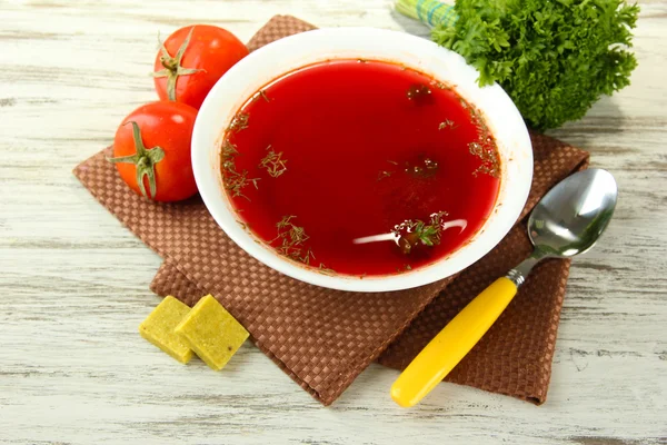 Cuenco de sopa con cubos de caldo sobre mesa de madera — Foto de Stock