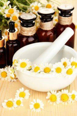 esans ve harç ahşap masa üzerinde papatya çiçeği.