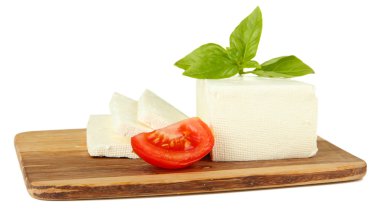 koyun peyniri üzerine beyaz izole kesme tahtası üzerinde domates ve fesleğen ile