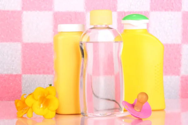 Baby cosmetics in bathroom on pink tile wall background — Stock Photo, Image