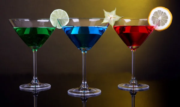 Alkoholhaltiga drinkar i martini glas på mörk gul bakgrund — Stockfoto