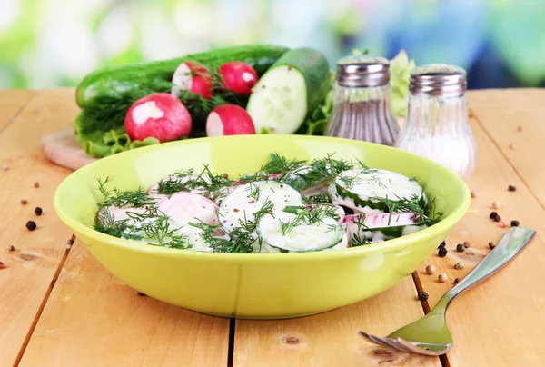 Vitamin vegetable salad in bowl on wooden table on natural background — Stock Photo, Image