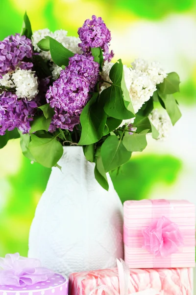 Bellissimi fiori lilla, su tavolo di legno su sfondo luminoso — Foto Stock