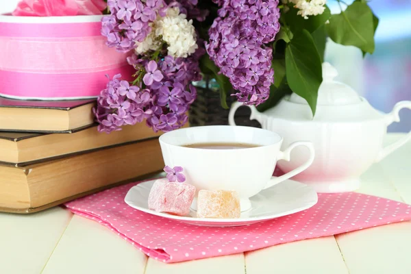 Samenstelling met prachtige lila bloemen, thee service op houten tafel op lichte achtergrond — Stockfoto