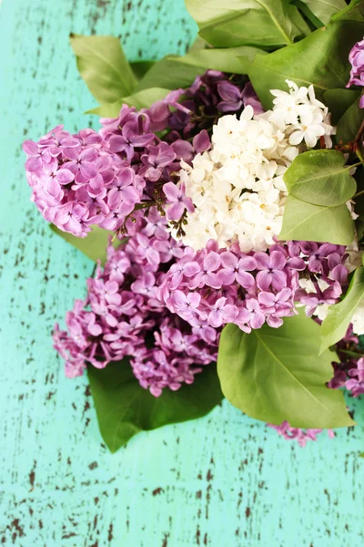 Beautiful lilac flowers, on color wooden background — Stock Photo, Image