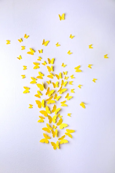 Paper yellow butterflies fly on wall in different directions — Stock Photo, Image