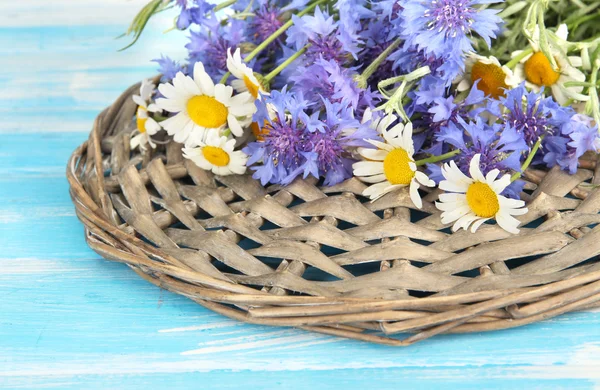 Beautiful bouquet of cornflowers and chamomiles on blue background — Stock Photo, Image