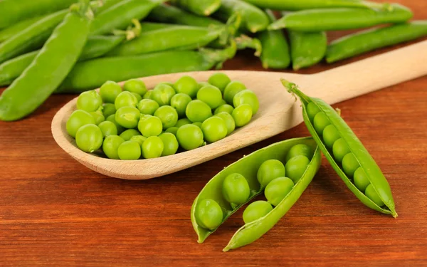 Guisantes verdes dulces sobre fondo de madera — Foto de Stock