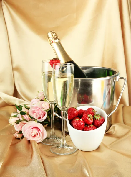 Романтичне натюрморт з шампанським, полуницею та рожевими трояндами на тлі кольорової тканини — стокове фото