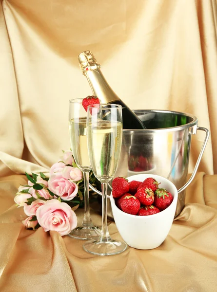 Romantic still life with champagne, strawberry and pink roses, on color fabric background — Stock Photo, Image