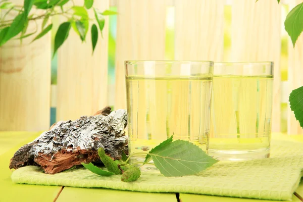 Glasses of birch sap on green wooden table — Stock Photo, Image