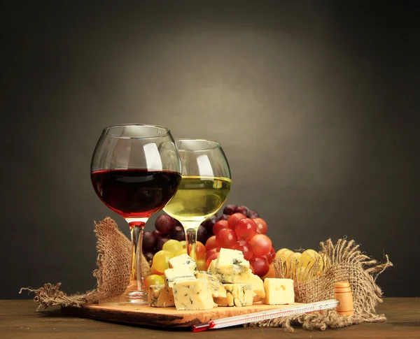 Sammansättning med vin, blå ost och druvan på träbord, på grå bakgrund — Stockfoto