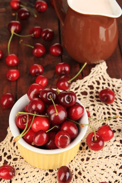 Bagas de cereja vermelhas maduras em tigela na mesa de madeira close-up — Fotografia de Stock