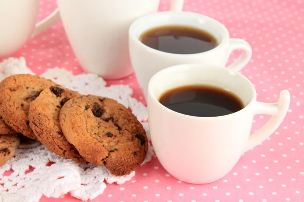 Tazas de café con galletas en la servilleta rosa de cerca — Foto de Stock