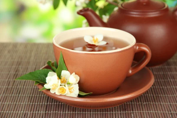Tasse Tee mit Jasmin, auf Bambusmatte, auf hellem Hintergrund — Stockfoto