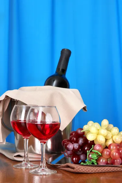 Wine and glasses on round table on cloth background