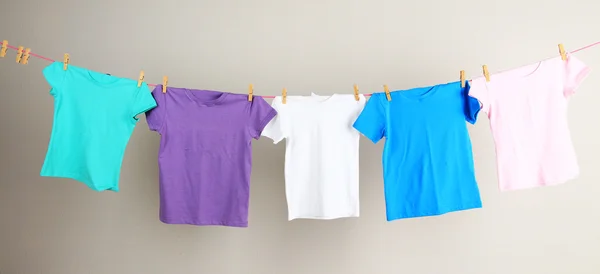 Laundry line with clothes on wall background — Stock Photo, Image